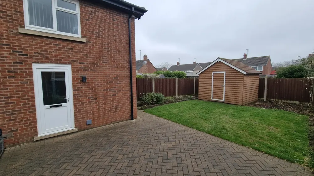 Example image: a herringbone block paved patio behind a 1960s semi